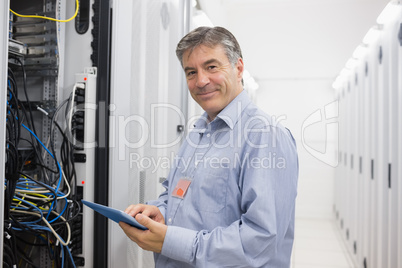 Smiling man doing maintenance on servers