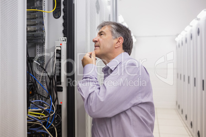 Man looking up thoughtfully into server locker