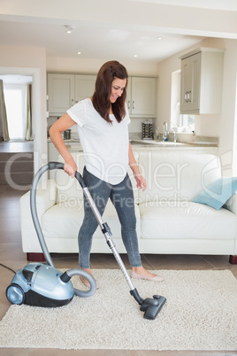 Woman standing at the living room hoovering