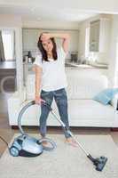 Tired woman hoovering the living room