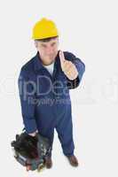 Mature man with tool bag showing thumbs up sign