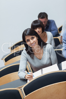 Smiling woman looking up from note taking
