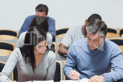 Man explaining to woman something on notepad