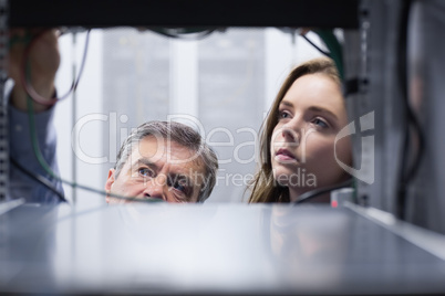 Technicians looking into empty server towers