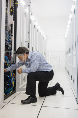 Man kneeling down and fixing wires
