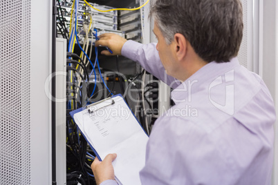 Electrician doing server  maintenance with clipboard