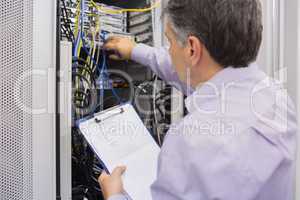 Electrician doing server  maintenance with clipboard