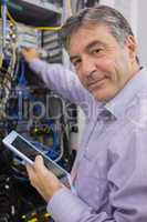 Man smiling while doing server maintenance with tablet