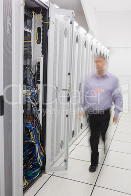 Man walking towards open server tower