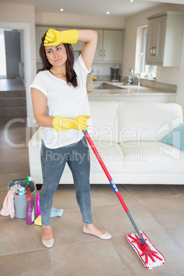 Woman with mop wiping her brow