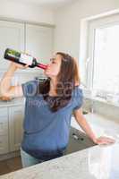 Woman drinking wine straight out of the bottle