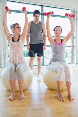 Two women at the gym with their coach