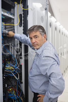 Technician looking up from adjusting server wires