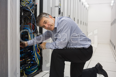 Technician kneeling and repairing a server