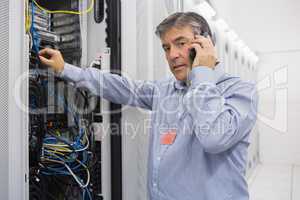 Technician working on server and phoning