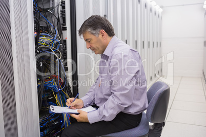 Technician writing notes on the servers