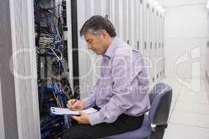 Technician writing notes on the servers