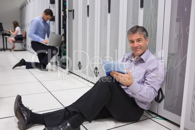 Smiling technician working on digital tablet on the floor