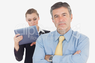 Confident businessman with coworker using tablet