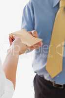 Businesswoman handing over envelop to businessman