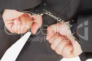 Businessman with handcuffs clencing fists