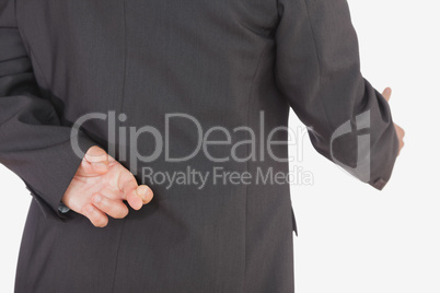 Businessman with crossed fingers offering handshake