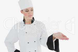Femal in chef's uniform looking at invisible product