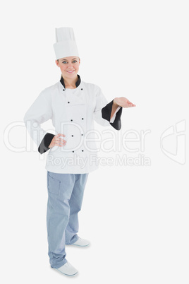 Portrait of female chef holding invisible product