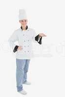 Portrait of female chef holding invisible product