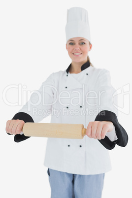 Happy woman in chef clothing holding rolling pin