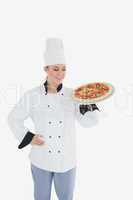 Female chef looking at pizza