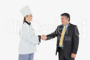 Businessman and female chef shaking hands