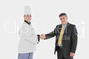 Happy businessman and female chef shaking hands