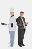Businessman holding digital tablet and chef with frying pan
