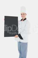 Female chef holding black billboard