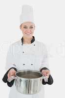 Happy female chef holding kitchen utensil