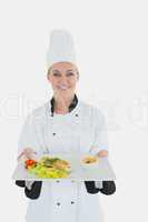 Female chef holding plate of healthyt meal