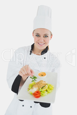 Female chef holding plate of healthy food