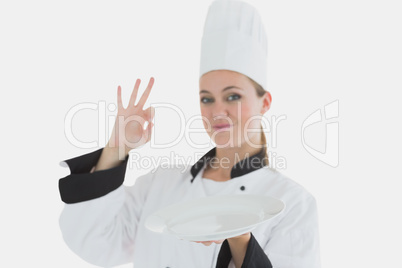 Chef with an empty plate gesturing ok sign