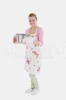 Portrait of young maid in apron holding utensil