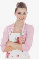 Happy young maid in apron holding whisk
