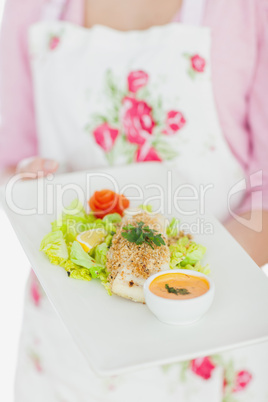 Maid holding plate of healthy food