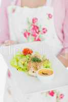 Maid holding plate of healthy food