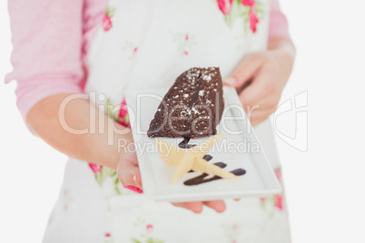 Maid holding plate of tempting pastry