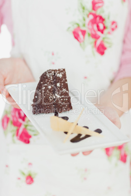 Woman holding plate of delicious pastry