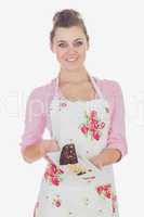 Young woman holding plate of tempting pastry