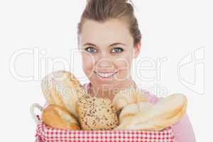 Happy young woman with basket full of breads