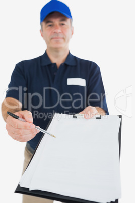 Delivery man holding out clipboard for signature