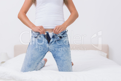 Woman trying to close her jeans