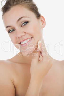 Young woman applying facial powder